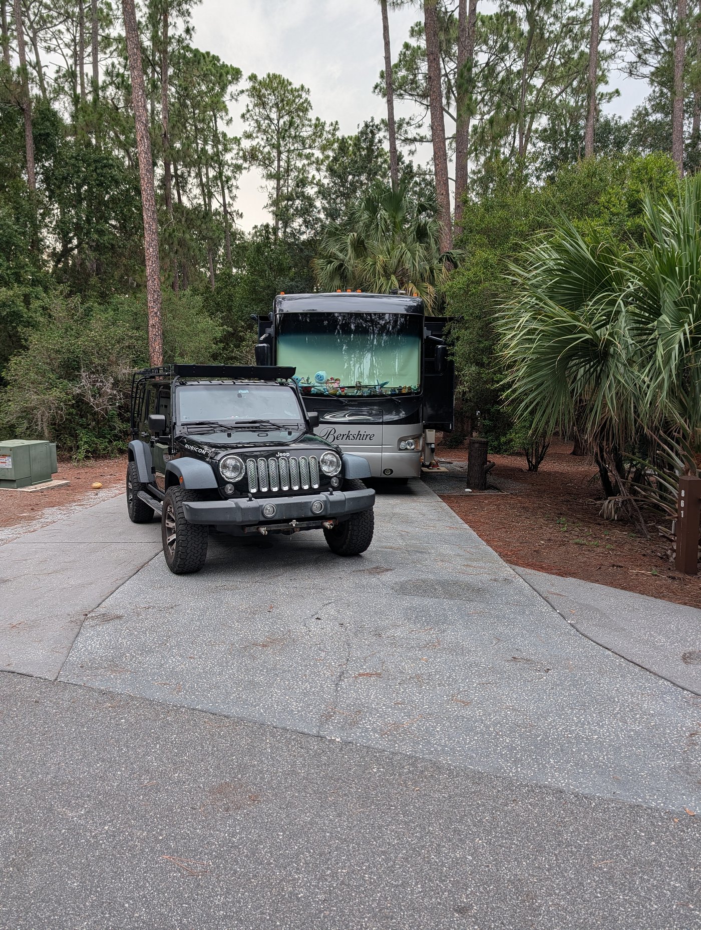The family Jeep and Class A motorhome parked at a Fort Wilderness campsite