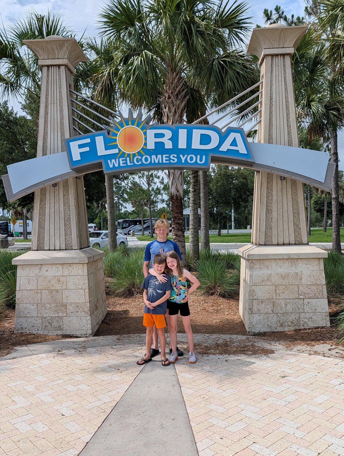 The kids under the Florida Welcomes You sign